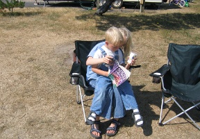 Back at the campground Johanna reading a book to Tuomas